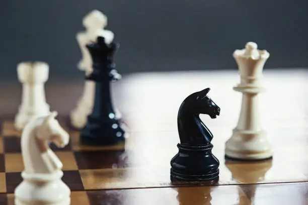 Chess pieces on a wooden chessboard.