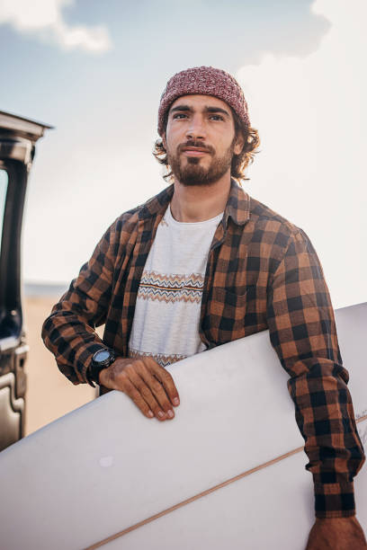 istock Hipster surfer taking surfboards from the car trunk 1393549446