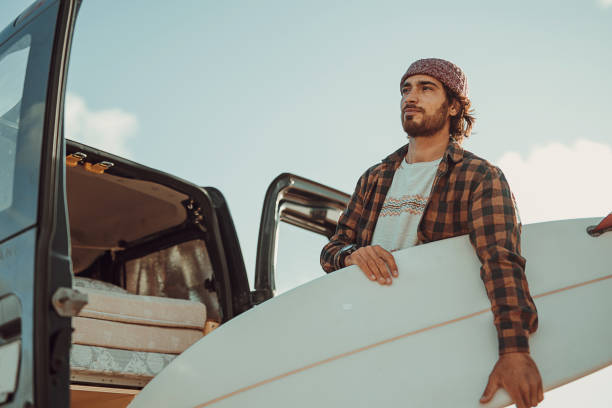 istock Hipster surfer taking surfboards from the car trunk 1393549467