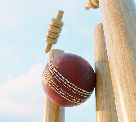 Wooden cricket wickets with dislodging bails on a day sky background - 3D render