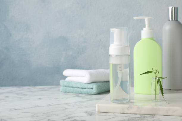 istock Bottles of hemp cosmetics with green leaf on white marble table, space for text 1393555541