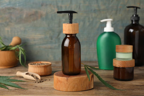 istock Different hemp cosmetics and green leaves on wooden table 1393555724