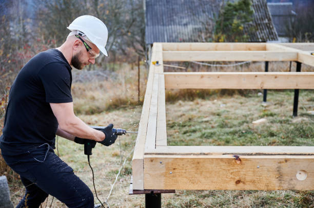 istock Man worker building wooden frame house on pile foundation. 1393555934
