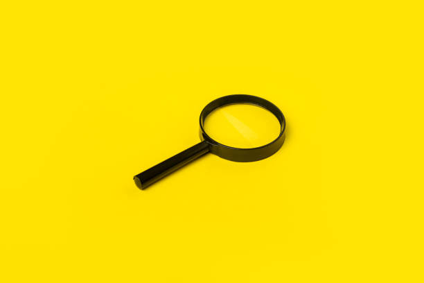 istock magnifying glass loupe search symbol on yellow background. Top view, flat lay 1393556468