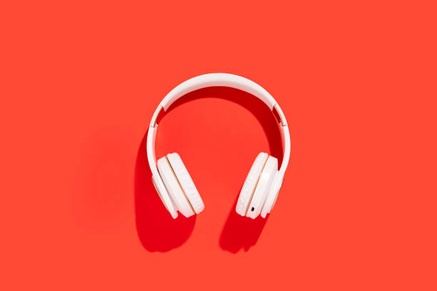 istock White wireless headphones on a red background. Top view, flat lay. 1393557750