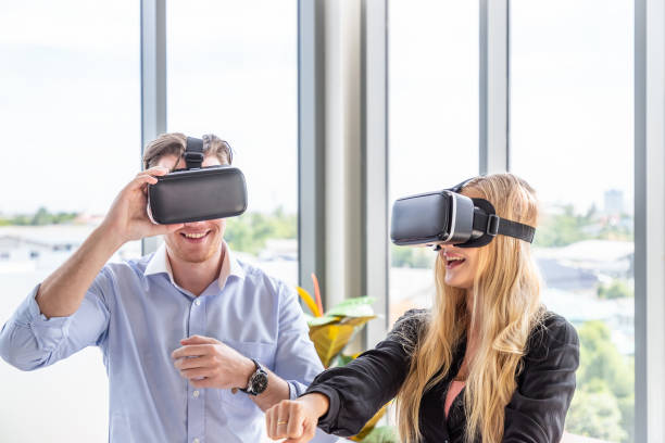 istock Caucasian couple wearing virtual reality VR headset goggle playing futuristic game 1393557971