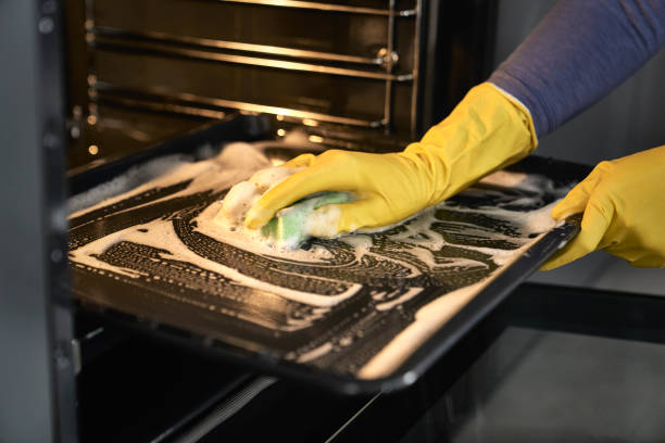 Close up of caucasian woman cleaning oven at home stock photo