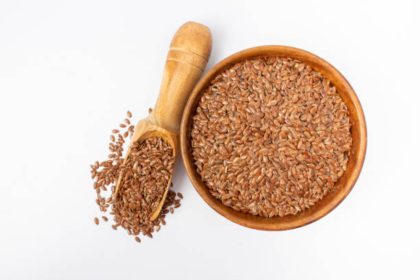 istock Flaxseed in wooden bowl and spoon on white background 1393560448