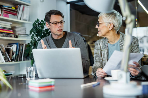 istock Two entrepreneurs talking while making plans on laptop in the office. 1393565065