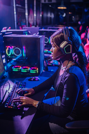 Beautiful young alternative black female playing online games in a Esports Gaming Cafe