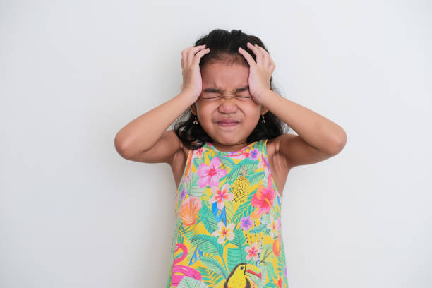 asian kid girl showing stressed expression with both hand on her head - pusing imagens e fotografias de stock