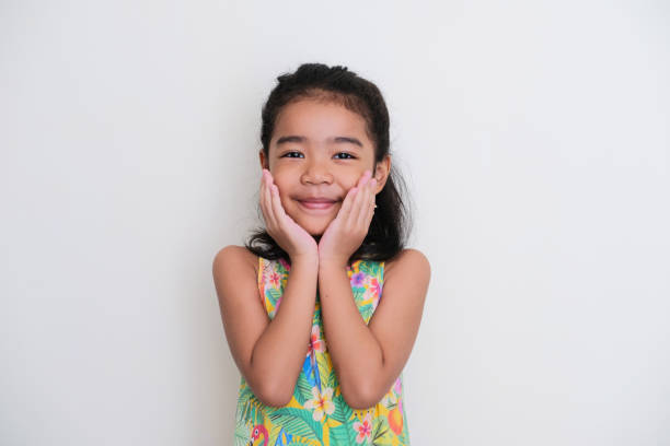 Asian kid girl smiling happy with both hand on her chin Asian kid girl smiling happy with both hand on her chin keluarga stock pictures, royalty-free photos & images