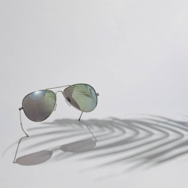 istock Sunglasses with palm tree shadow. Summer day on a beach concept idea. Relax vacation on a sunny day. Fashion accessories design 1393565412