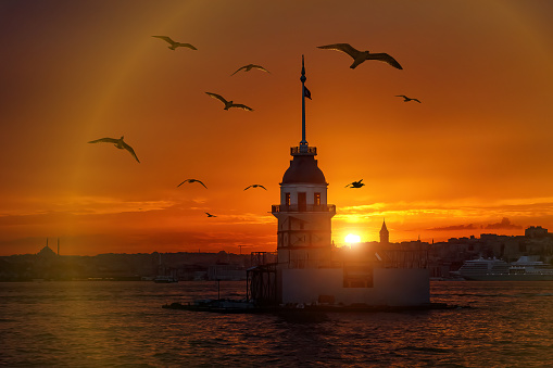 Fiery sunset over Bosphorus with famous Maiden's Tower - Kiz Kulesi - also known as Leander's Tower, symbol of Istanbul, Turkey.