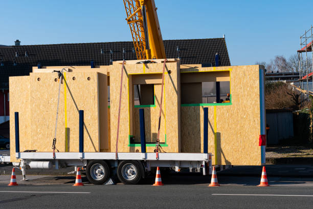 Ready for unloading panels of a wooden prefabricated house. Crane boom at the back. Ready for unloading panels of a wooden prefabricated house. Crane boom at the back. Car trailer. prefabricated building stock pictures, royalty-free photos & images