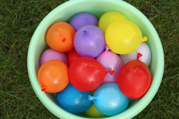 istock Basin full of water bombs on green grass, top view 1393567225