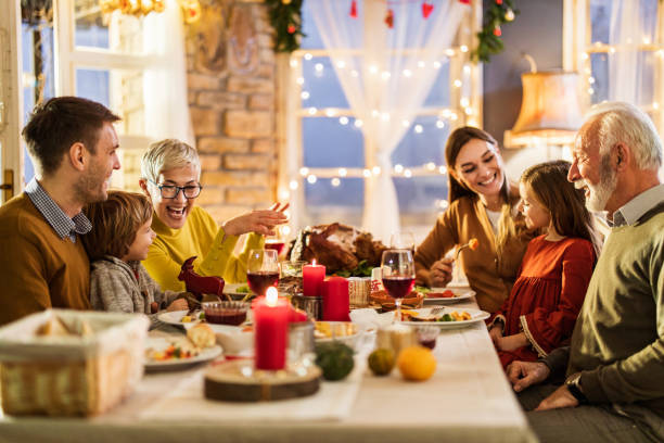 istock Happy multi-generation family enjoying in conversation during Thanksgiving lunch at dining table. 1393567590