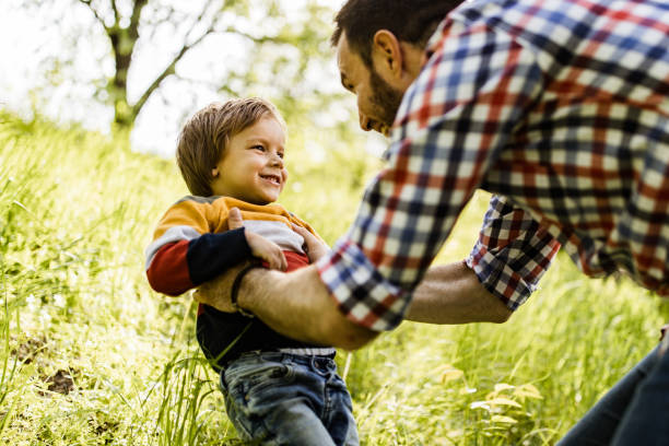 istock Happy single father having fun with his small son in the park. 1393569015