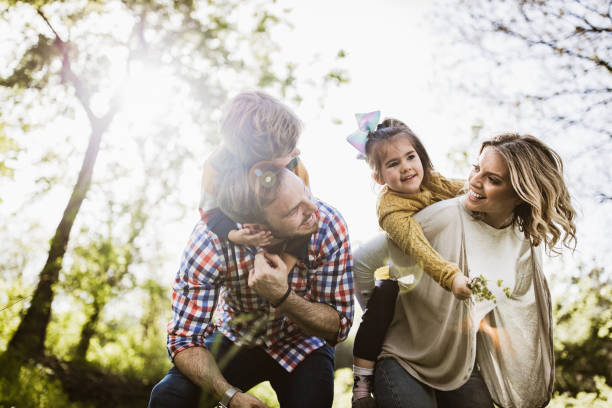 istock Playful family having fun while piggybacking in nature. 1393571287