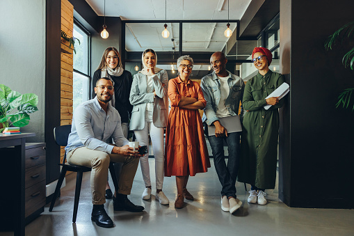 Successful business professionals smiling cheerfully in a modern office. Group of multicultural businesspeople running a creative startup in an inclusive workplace.