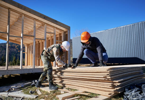 charpentier utilisant une scie circulaire pour couper le panneau osb pour la construction d’une maison à ossature en bois. - wood chipboard photos et images de collection