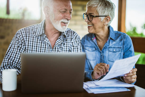 istock Mature couple paying their bills over computer on a terrace. 1393574599