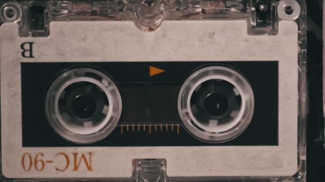 Vintage Audio Tape with a Blank Label Spinning in Cassette Recorder, Close-up