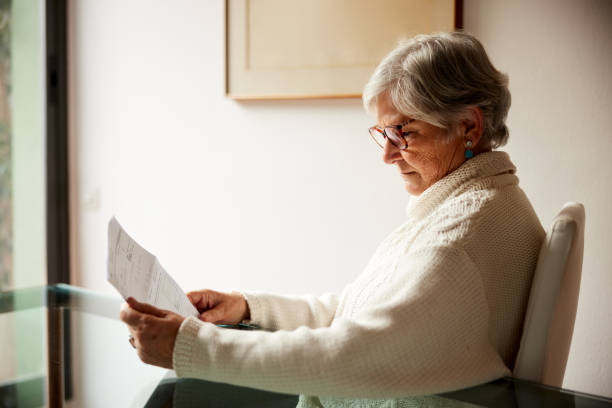 istock Senior woman at home reading a letter. 1393576547
