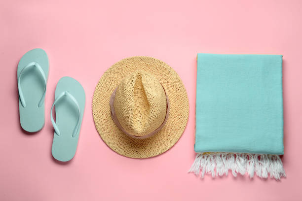 istock Beach towel, flip flops and straw hat on pink background, flat lay 1393576933