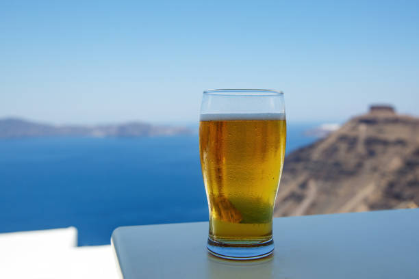 Cold beer glass on the blue sea background.