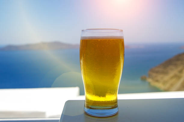 Cold beer glass on the blue sea background.