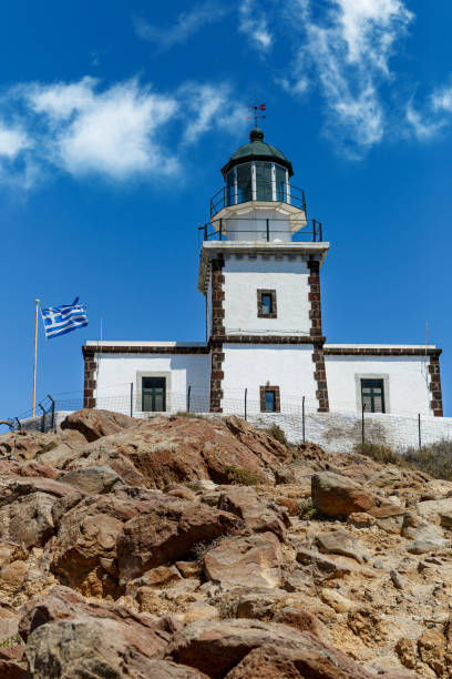 istock Old lighthouse with Greece flag on blue sky background. 1393577844
