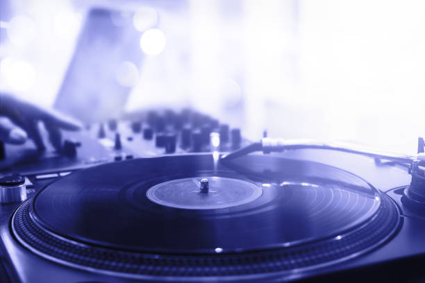 Old vinyl spinning on turntable, colored in pantone color of 2022 year - Very Peri, image shallow depth