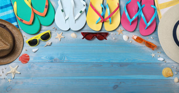 istock Many different flip flops and beach objects on light blue wooden background, flat lay. Space for text 1393578146