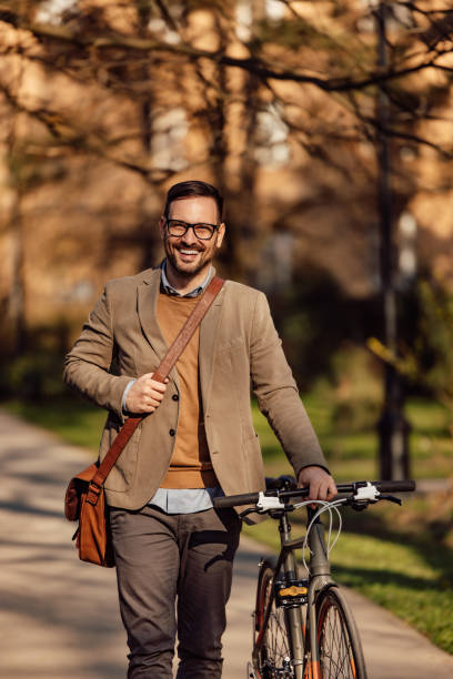 istock Portrait of a smiling man, coming back from work, pushing a bicy 1393580210