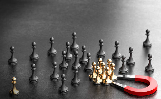 Inbound recruiting. Attract new talents. Horseshoe magnet attracting golden pawns over black background. Concept of inbound recruiting and attracting talents to the enterprise. 3d illustration. mergers and acquisitions stock pictures, royalty-free photos & images