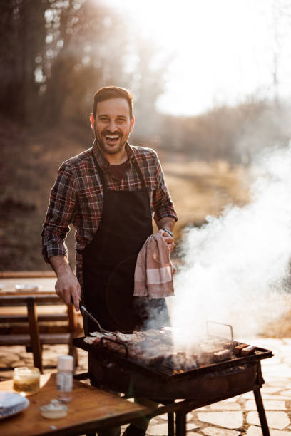 Portrait of a smiling man, making a lunch outside, preparing bar stock photo