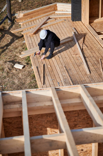 istock Man worker hammering while building wooden frame house. 1393580419