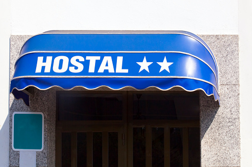 Detail of two star hostel sign on blue awning , seen from the street.