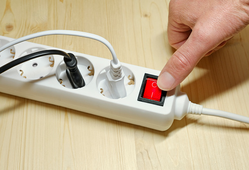 Electrical plug and multiple socket in use on the floor, Close up.