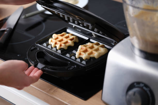 istock Cooking waffles in waffle iron at home closeup 1393585180