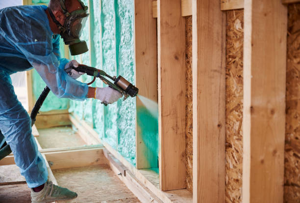 istock Worker spraying polyurethane foam for insulating wooden frame house. 1393586235