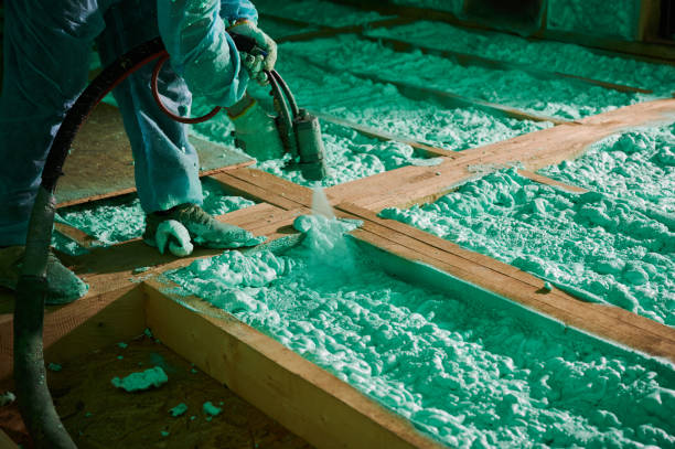 Worker spraying polyurethane foam for insulating wooden frame house. Male builder insulating wooden frame house. Cropped view of man worker spraying polyurethane foam on floor inside of future cottage, using plural component gun. Construction and insulation concept. spray insulation stock pictures, royalty-free photos & images