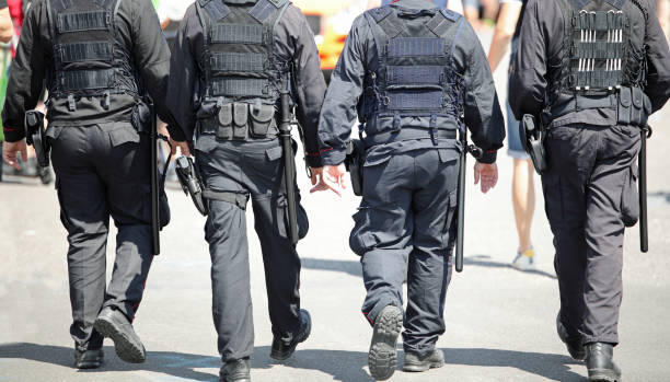 istock four policemen with weapons and bulletproof vests while patrolling the city also with truncheons to avoid riots 1393587744