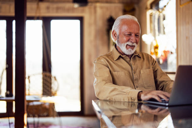 istock Smiling senior man looking at the laptop, reading something funn 1393587866