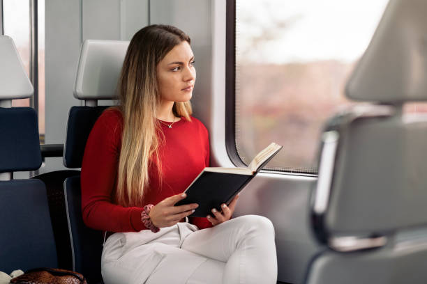 istock Girl Reading Book in Train 1393588208