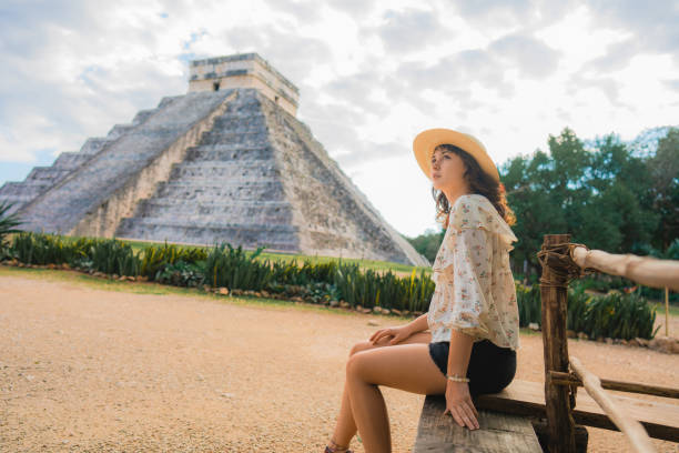 istock Woman sitting with view on Chichen Itza pyramid in Mexico 1393588252