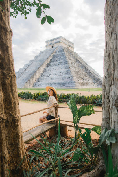 istock Woman sitting with view on Chichen Itza pyramid in Mexico 1393588393