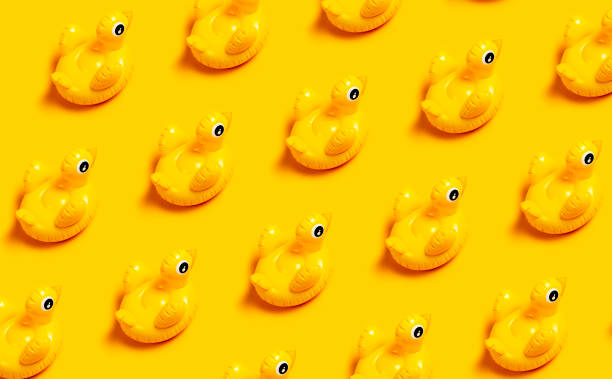 istock Creative summer beach concept. Pattern of Inflatable mini yellow chicken or duckling on yellow background, pool float party. Flat lay copy space. Trend Inflatable Children toy for swimming 1393589226