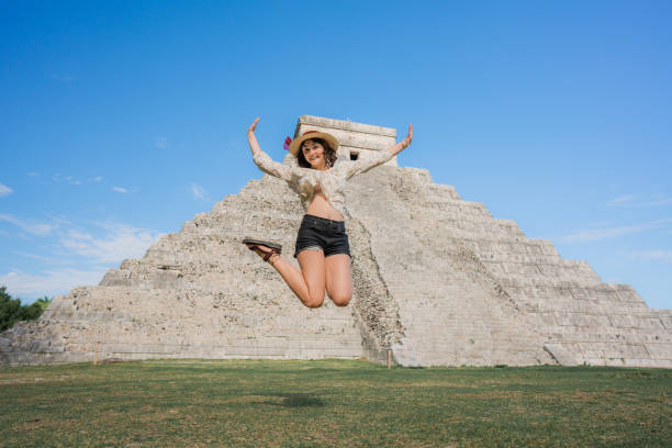 istock Woman jumping near Chichen Itza pyramid in Mexico 1393589240